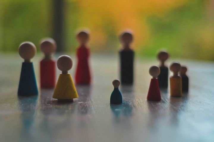 Figurines de constellation en bois colorées disposées sur une table, une petite figurine bleue au premier plan