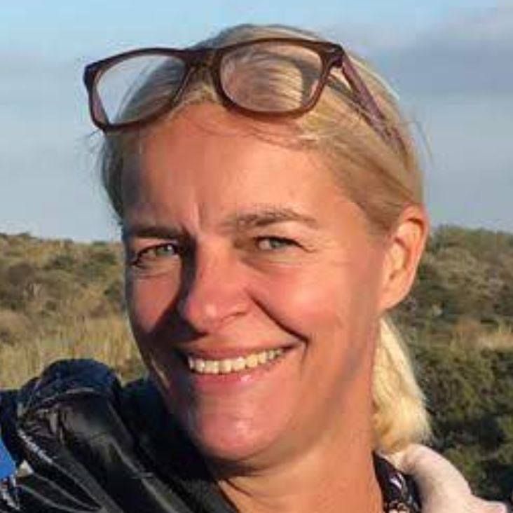 Christine den Boer, psychopraticienne spécialisée en constellations familiales, souriante en extérieur